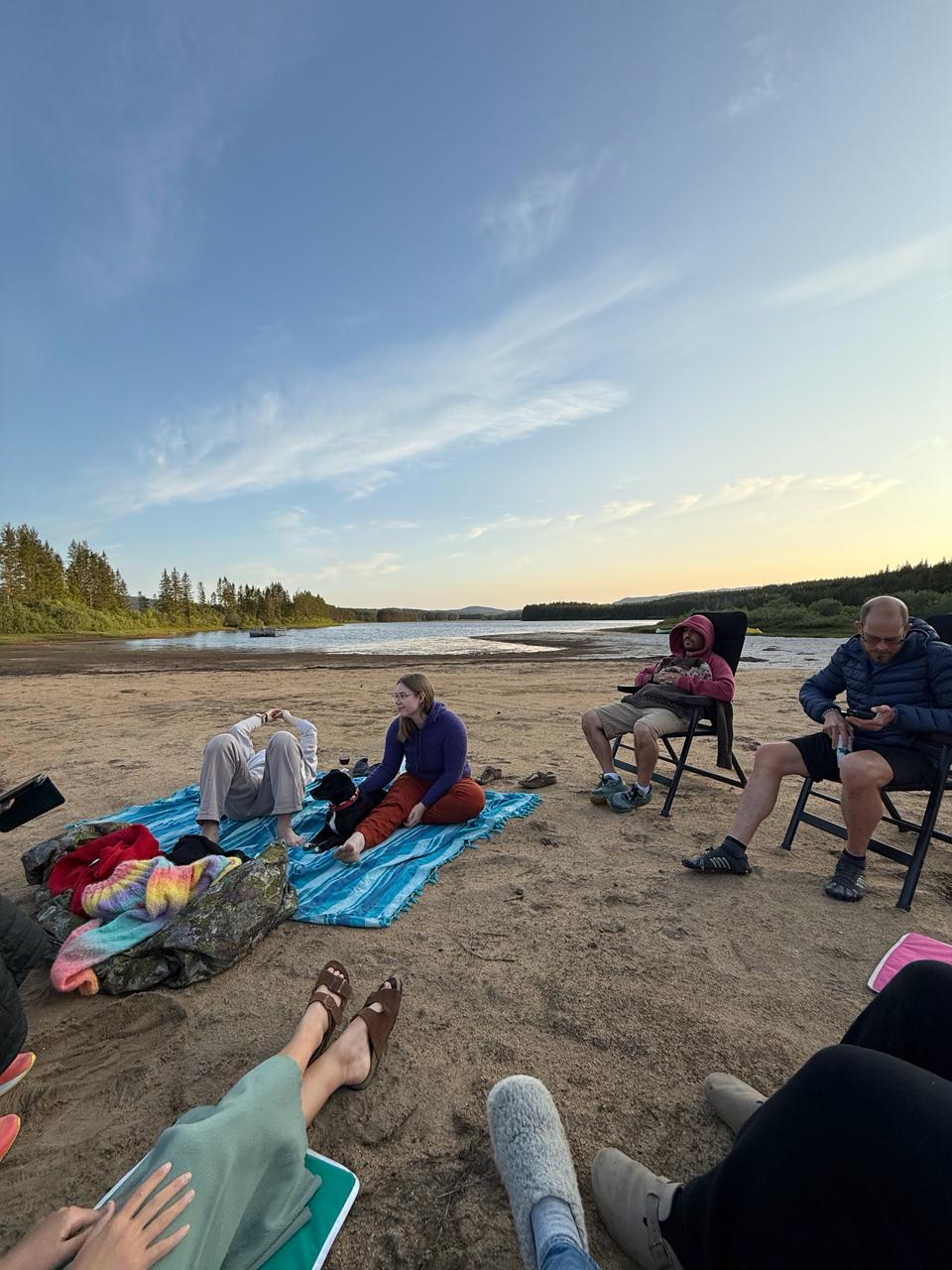Camp community relaxing at sunset